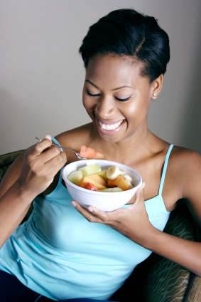 Woman enjoying a bowl of fresh fruits.