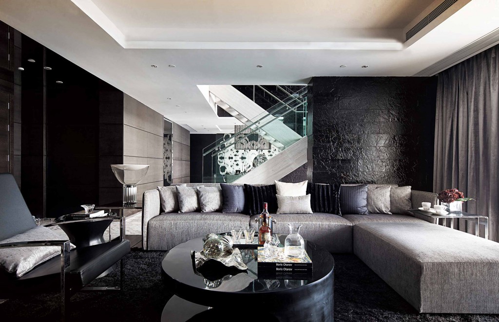 modern-living-space-black-fur-rug-grey-sofa-cushion-black-metal-chair-black-glass-coffe-table-recessed-ceilling-light-staircase-handrail-curtain-black-wall